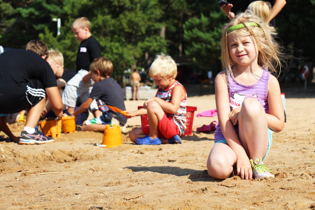 Barn leker på stranden vid Bomstadbadens barnvänliga camping.