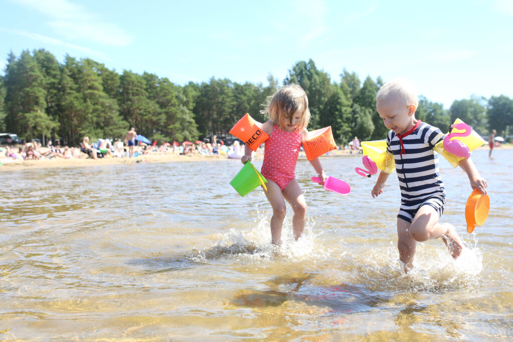 Två barn leker i vattnet vid Bomstadbadens camping i Karlstad.