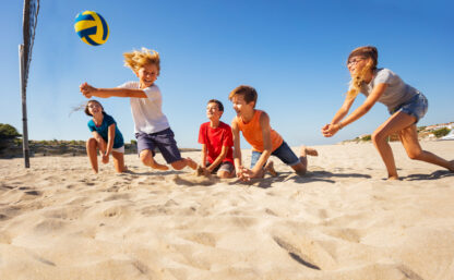 Boy making bump pass during beach volleyball game