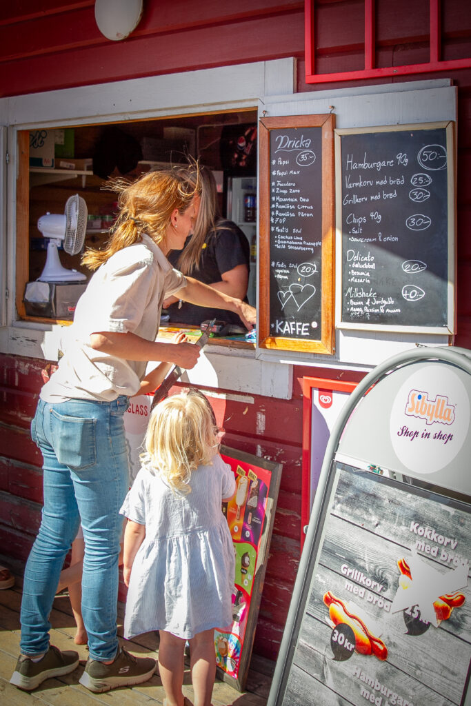 Två personer handlar från kiosken vid Bomstadbadens camping i Karlstad.
